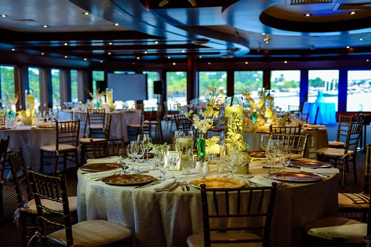 Elegant dining tables set for a company event aboard a yacht